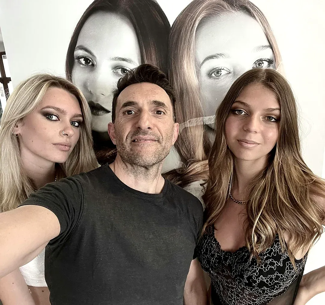 Selfie di Matteo con due ragazze davanti ai poster del salone